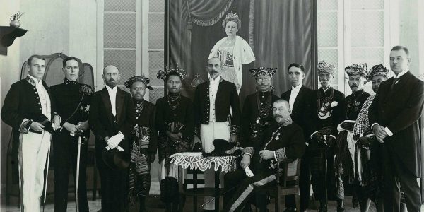 Raja Kupang Nicolaus Nisnoni dan fetor Fetor didaratan Timor foto bersama dengan Residen Timor, C. Schultz, di muka lukisan Ratu Wilhelmina, tahun 1925.