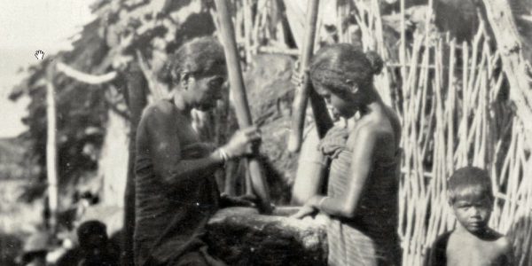 Seorang ibu dan anak perempuannya menumbuk jagung, pengganti beras, di Lomblen, 1929.